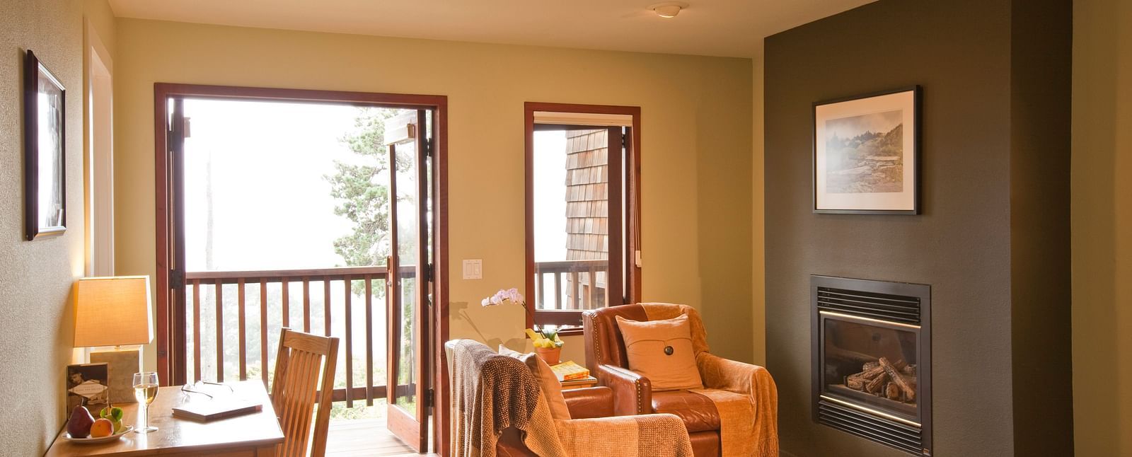 A spacious, elegant hotel room with large windows showcasing beautiful greenery outside, offering a tranquil and inviting atmosphere - Brewery Gulch Inn & Spa
