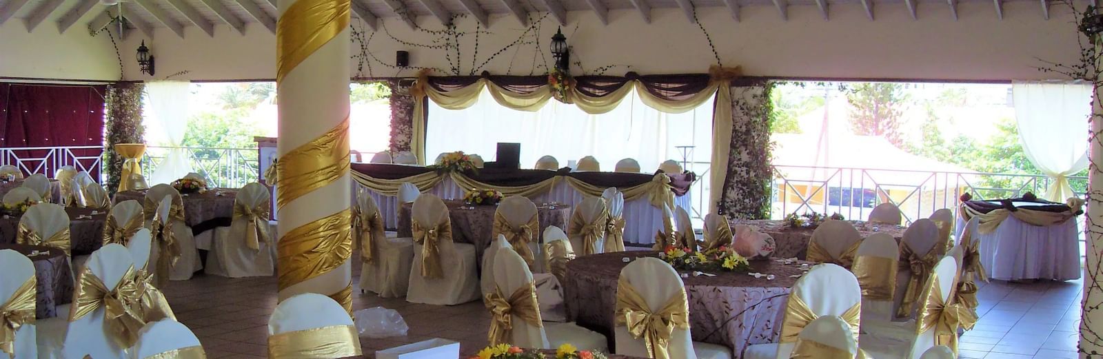 An event space with tables and chairs set up under a covered structure, possibly for a reception or meal | Roof Terrace | Altamont Court, Jamaica