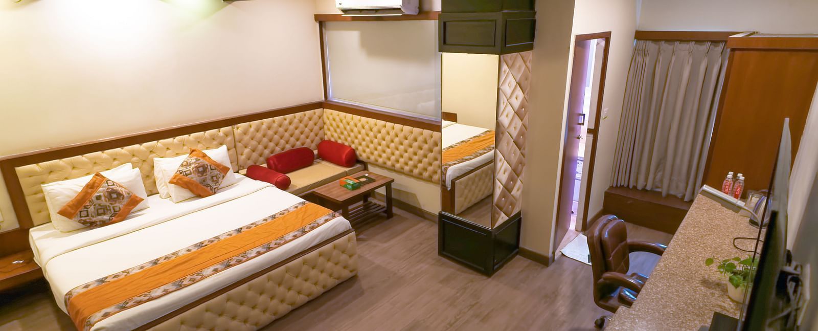 A view of the Deluxe Room featuring a bed with wooden interior at Hotel Ashok Nagpur.