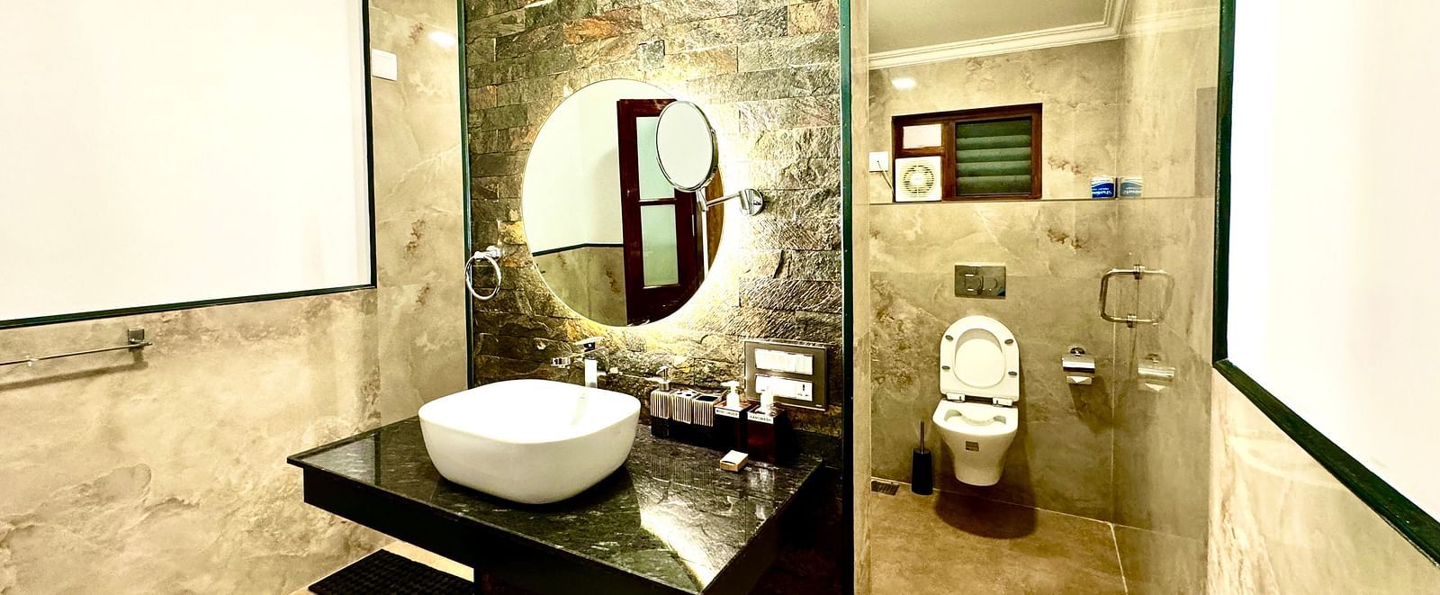 Stylish bathroom with a unique mirror, toilet, and decorative wall art - BluSalzz Collection - Tranquil Resort, Wayanad