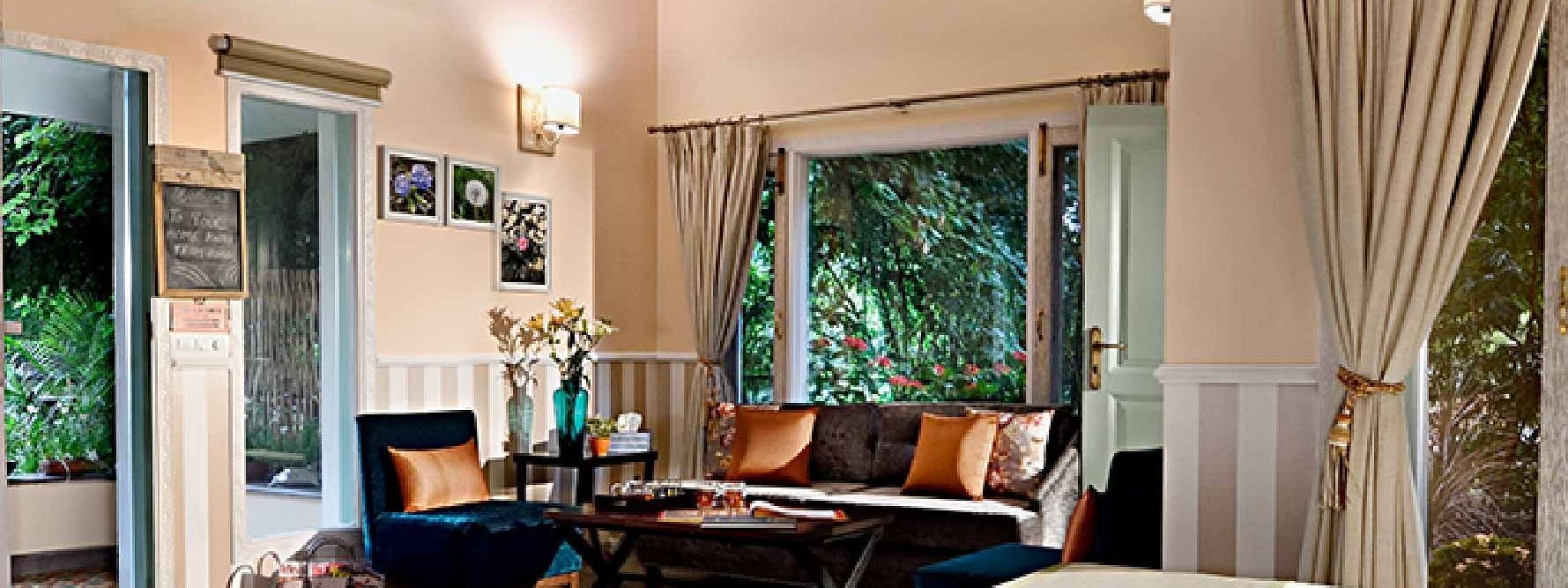 Interior of a guest room with a double bed, sofa, and window view at Karma Chalets.