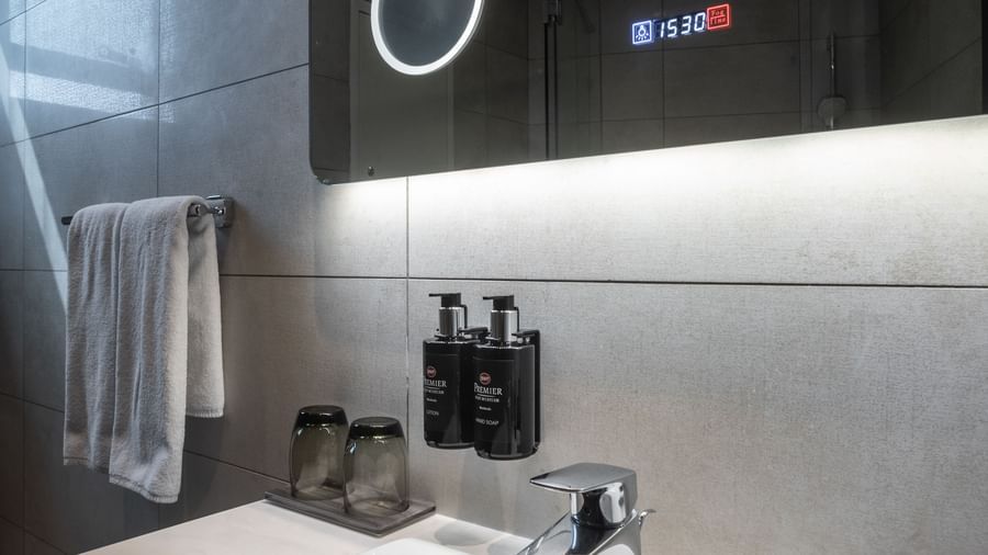 Bathroom with the mirror, sink, and mounted soap dispensers at Best Western Premier Westlands