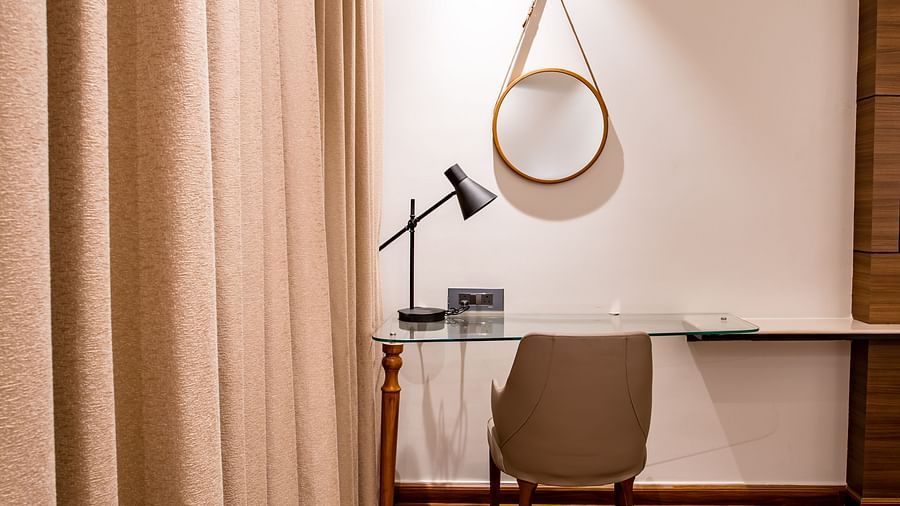 the study table with a mirror on the wall inside one of the rooms - Wedlock Greens Hotel Resorts Dhanbad