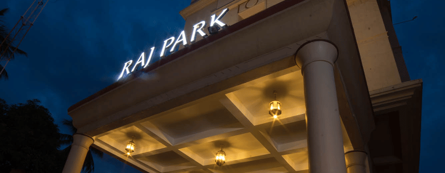 Facade of Hotel raj Park, chennai with dark sky in the backdrop.