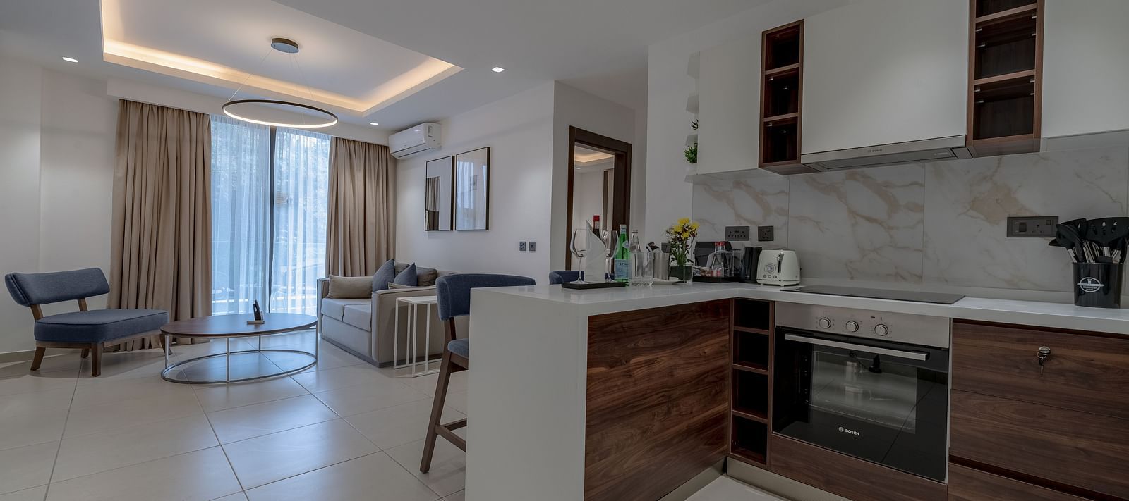 Modern kitchen in a Premier Suite with stainless steel appliances and wood cabinetry. - The Pelican Hotel, Accra