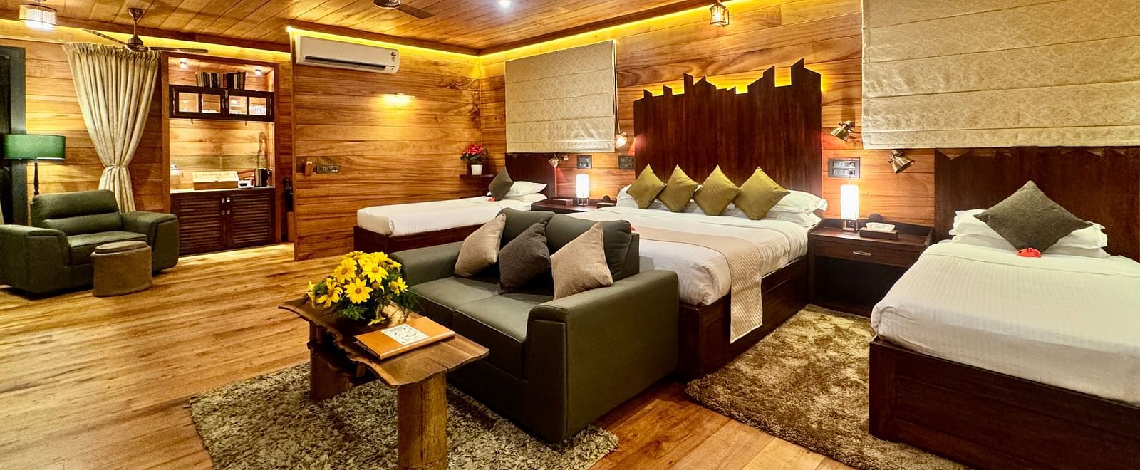 A warm room featuring a double bed, armchairs, a small table, and wooden panelling - BluSalzz Collection - Tranquil Resort, Wayanad