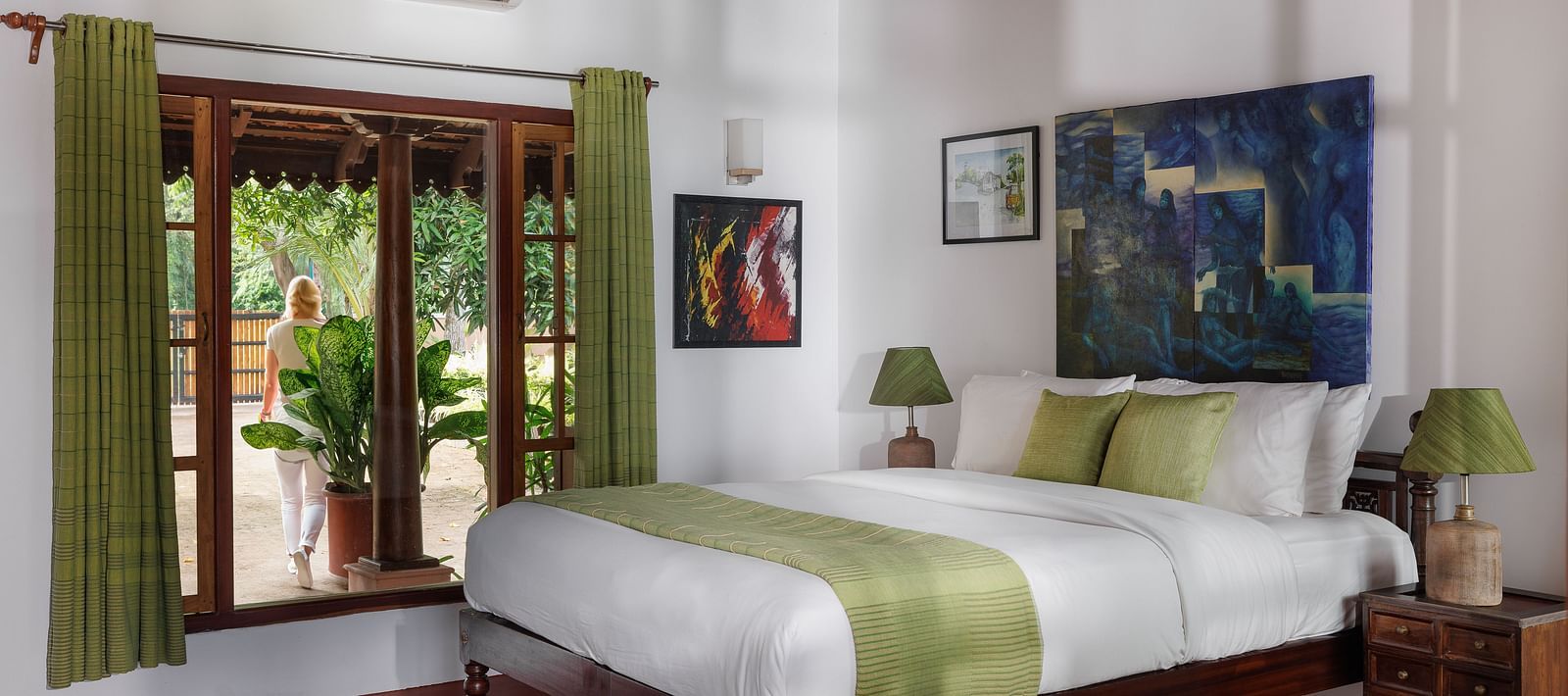A room with a bed, wooden decorative items, and a glass window overlooking the view - BluSalzz Villas - Muhamma Resort, Alleppey