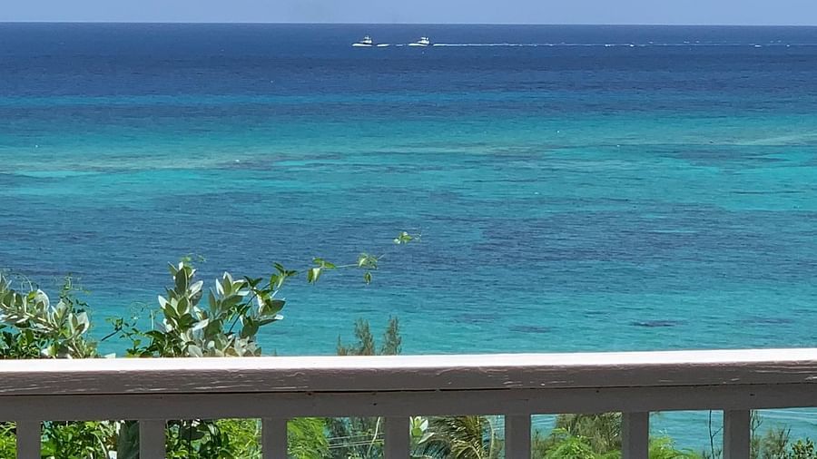 View of an ocean beyond a wooden balcony railing | A Stone's Throw Away