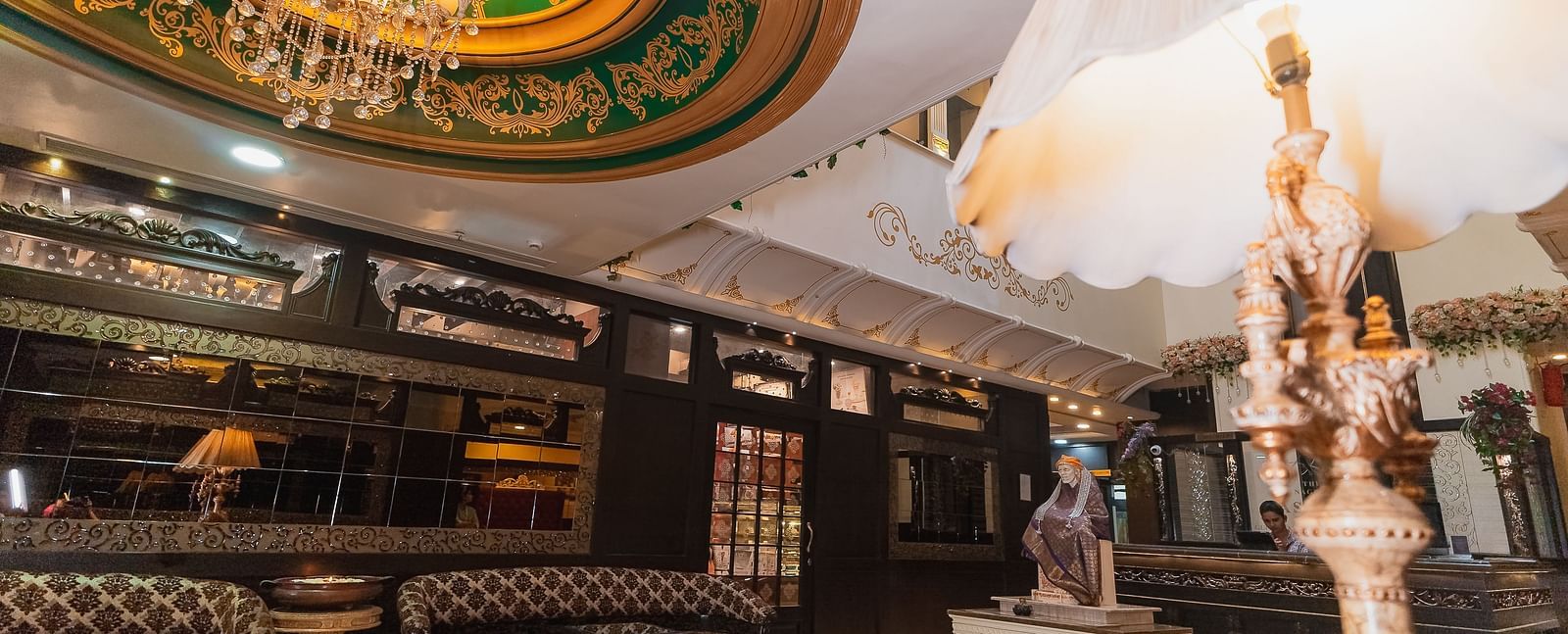 Hotel Ashok Nagpur featuring a decorative sculpture in the lobby and a glimpse of the reception area. 