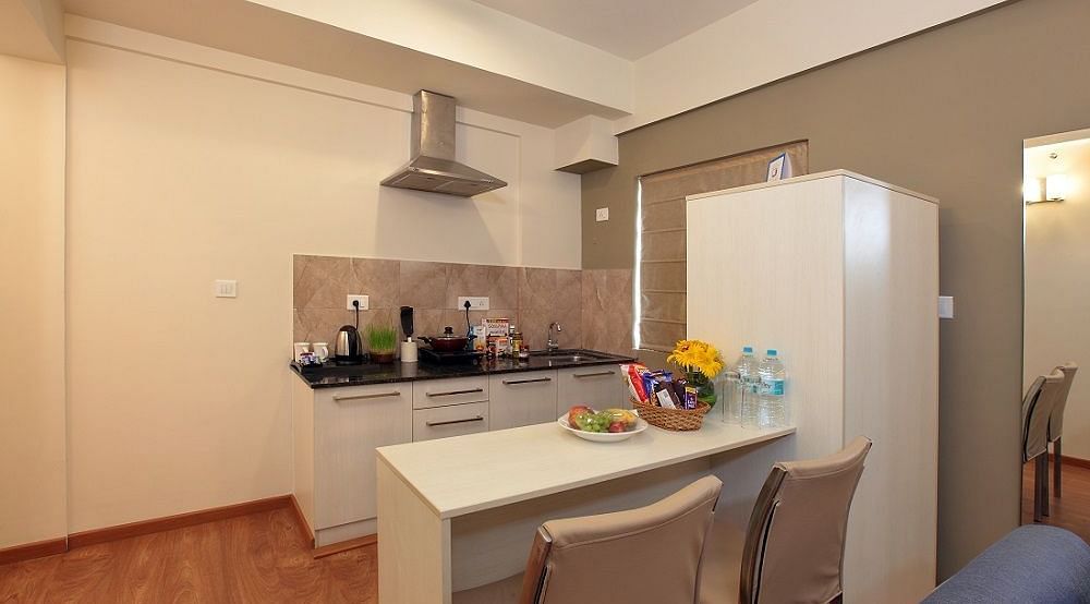 Kitchenette area of Deluxe Suite at Starlit Suites, Bangalore with a waterfall island seating