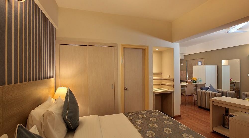 Deluxe room at Starlit Suites, Bangalore with a double bed and a separate living area