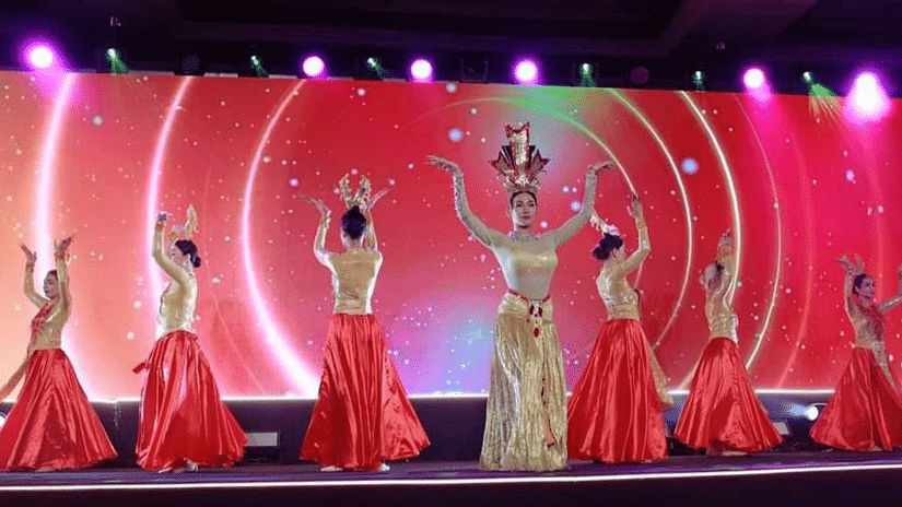Dance performance with artists in red and gold costumes on a brightly lit stage at Central Hotels.Untitled design
