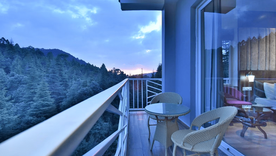 The balcony of the luxury room with two chairs and a coffee table overlooking the view - DLS Ark Holiday Inn, Dalhousie