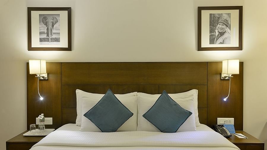 Front view of Premium room with plush bed and bedside table - Clarks Collection, Vadodara