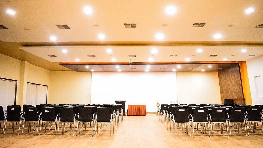 a banquet hall with a classroom styled seating and bright overhead lighting - Camel Valley Resort, Igatpuri