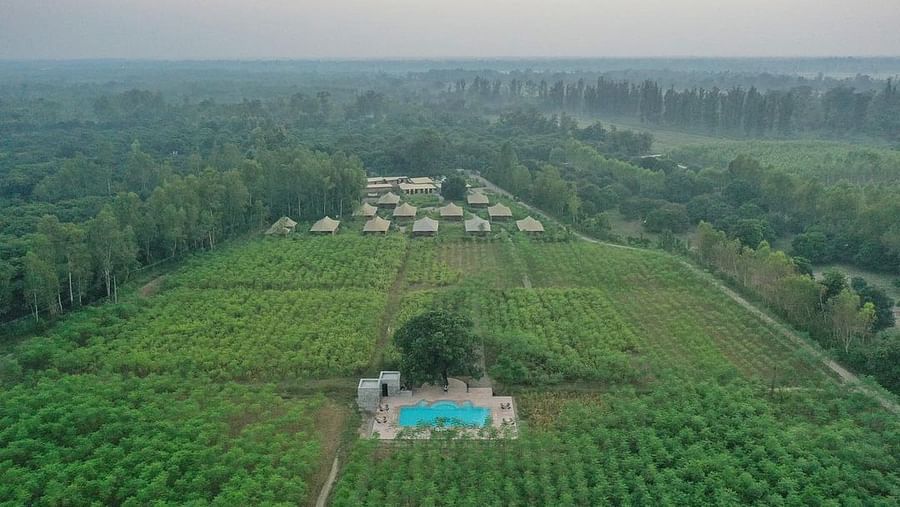 An aerial shot of a water plant in front of our camps both of them covered in lush green setting - Claridges Collection