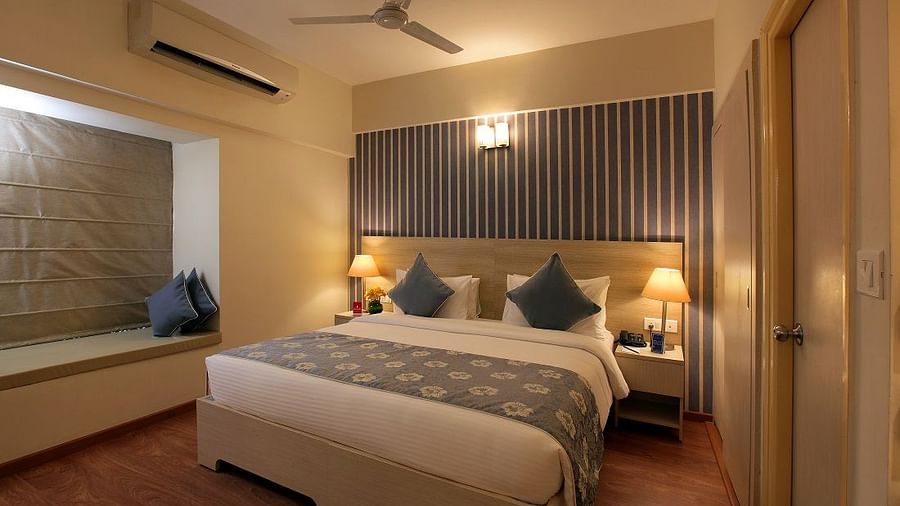 Deluxe room at Starlit Suites, Bangalore with a double bed and side tables