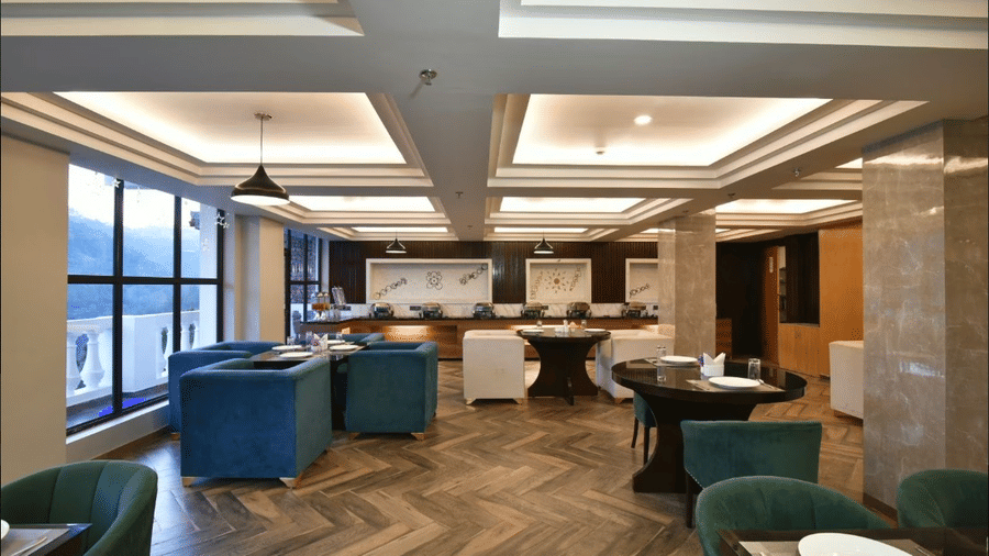 Stylish restaurant with modern seating, warm lighting, and large windows overlooking the hills at Claret Inn, Dalhousie.