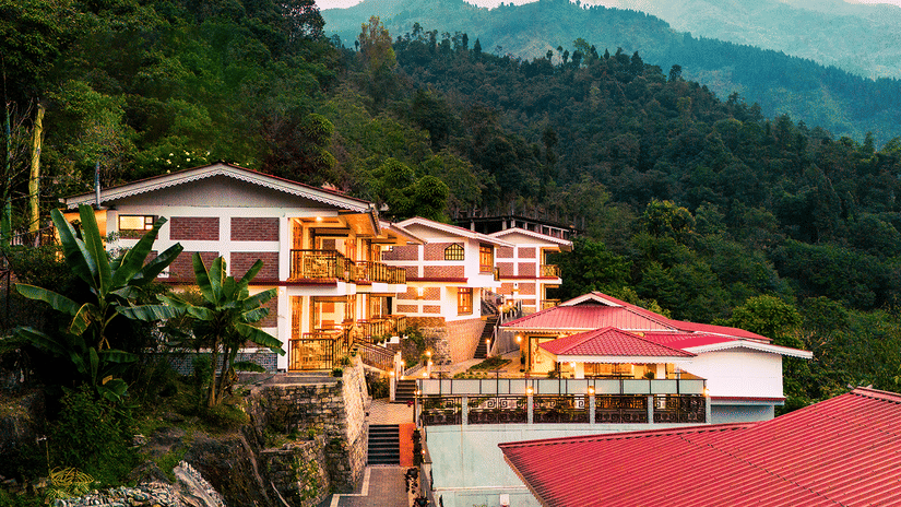 Voyage Songfum Retreat in Gangtok — a serene hillside hotel surrounded by lush greenery and offering scenic mountain views.