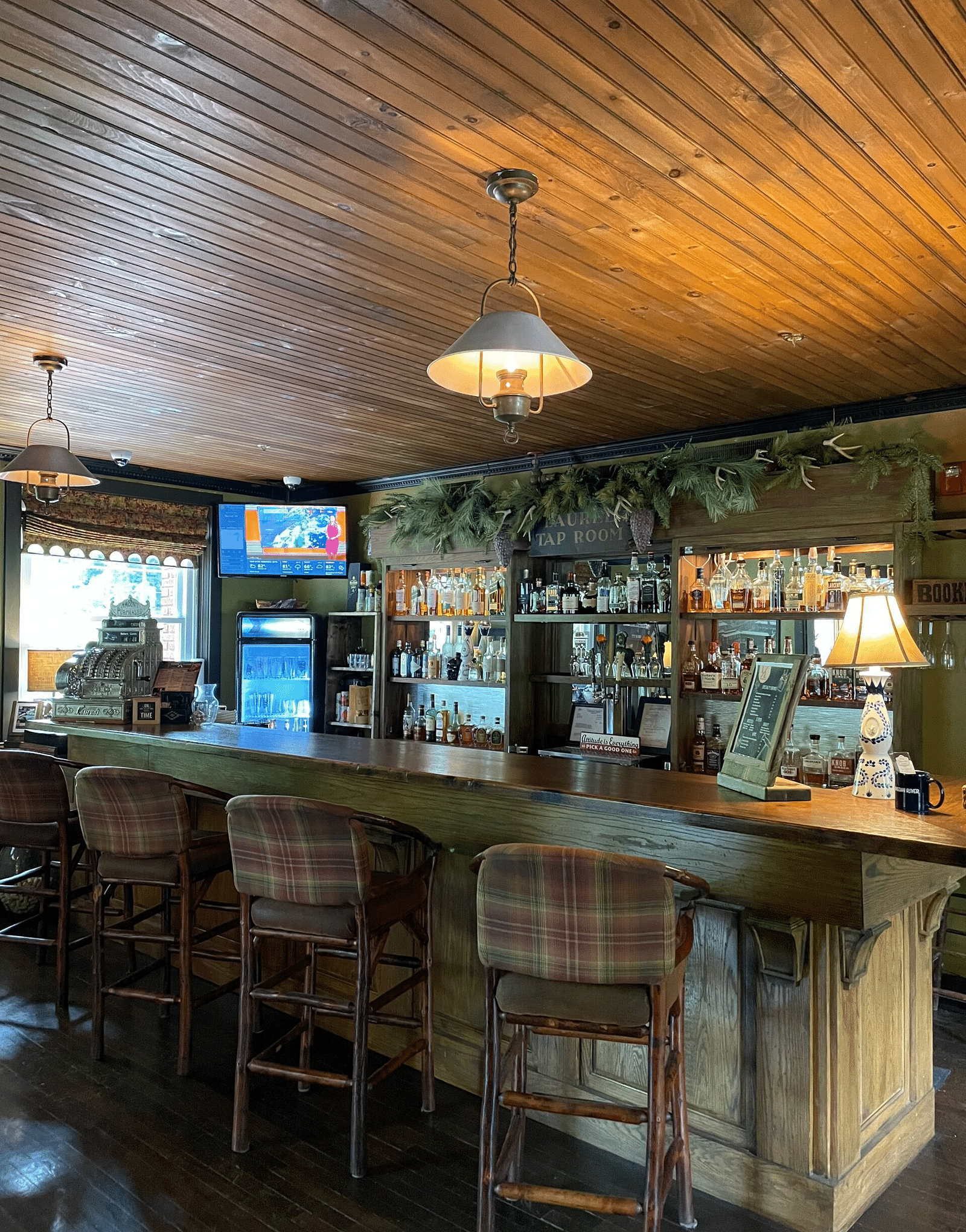 corner view image of the Laurel Lounge featuring elevated chairs at one side of the bar counter - Historic Tapoco Lodge