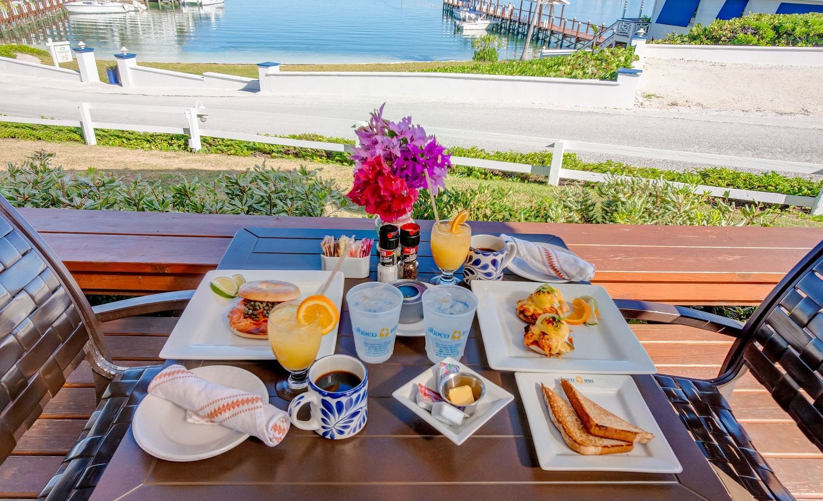 Breakfast plates on a wooden table near the sea | Abaco Inn