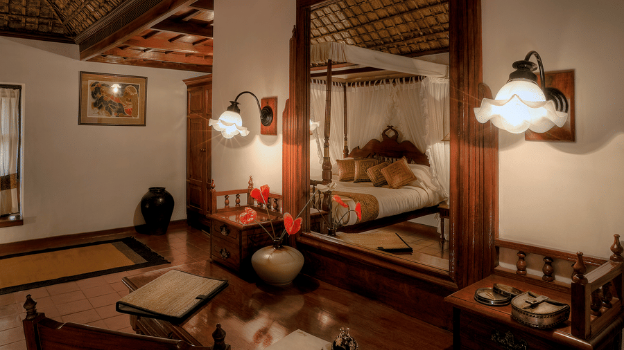 Traditional heritage bedroom with four-poster bed at Evolve Back Coorg