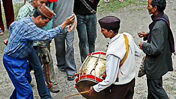 A musician playing the drum and a group of men dancing during Wedding celebration - Ramgarh Bungalows, Nainital.