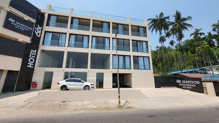 Facade of 6ix Seashore Hotel, Port Blair with a car standing in front of it