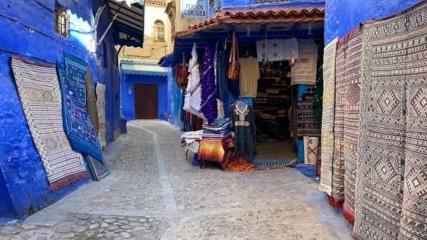 A facade image of a narrow entrance to houses painted in blue colour