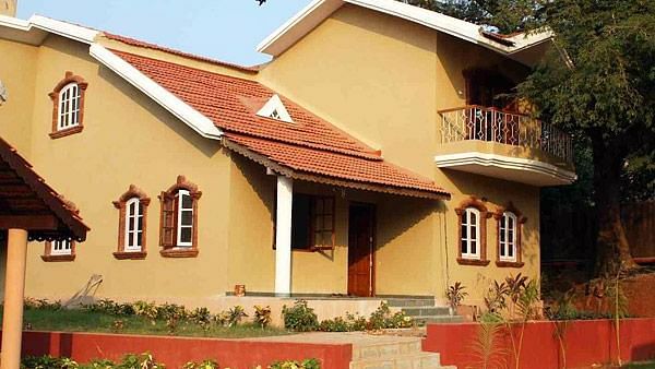 Facade of The Lighthouse Aguada in Goa during daylight with small shrubs next to the staircase