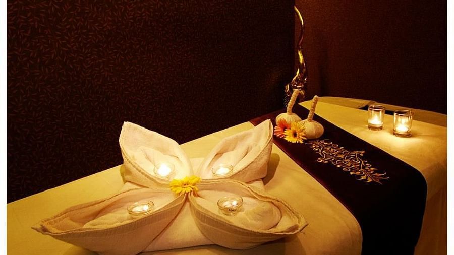 tea light candles kept on a towel folded intricately - IOSIS Spa & Wellness