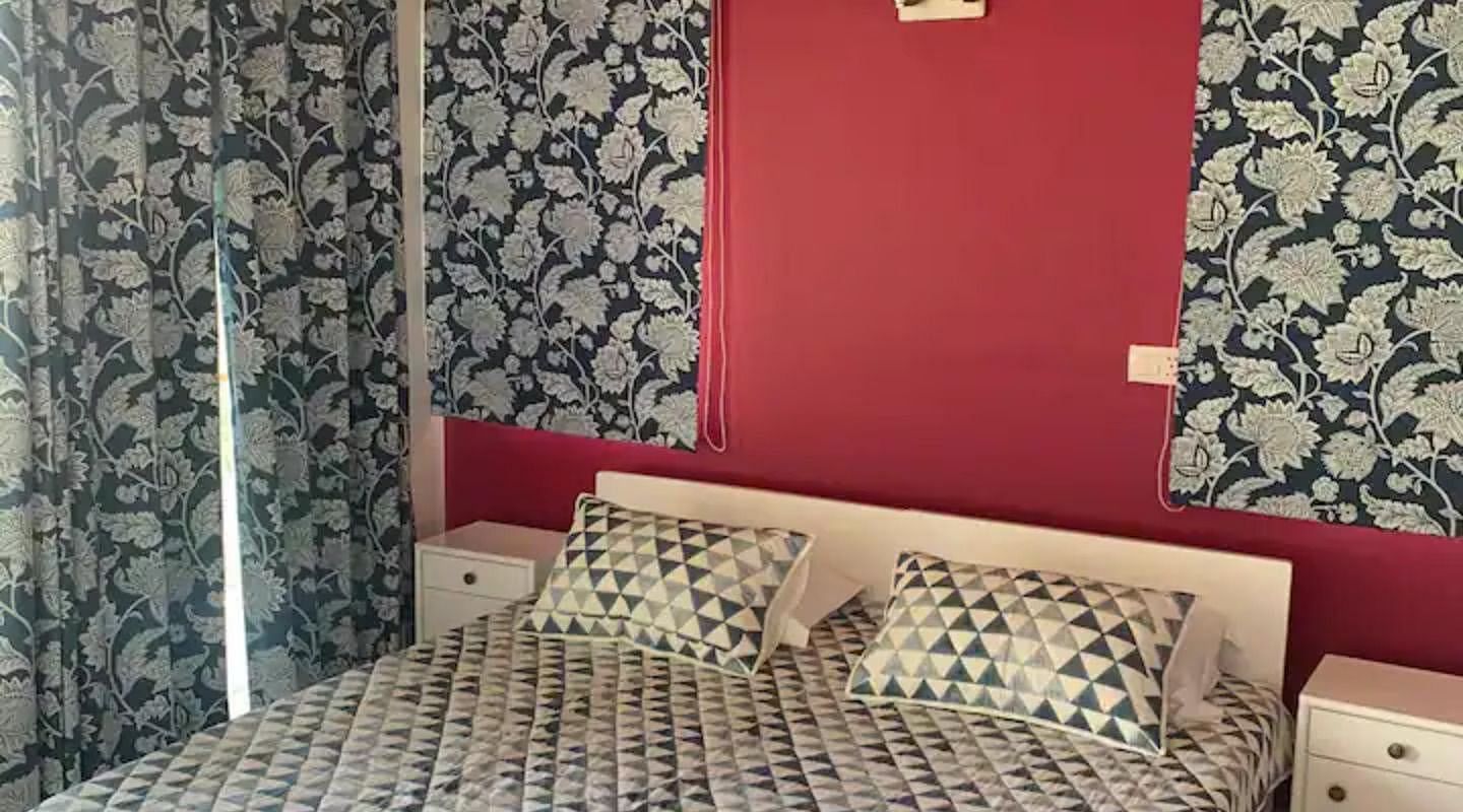 A large bed in a bedroom next to a nightstand at 3 BHK at SOUTHGATE KASAULI BY ZENQ.