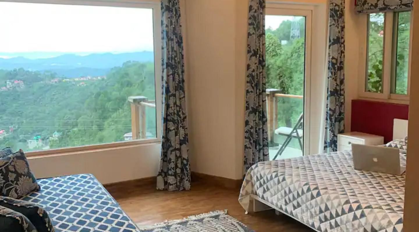 A large bed in front of a couch in a bedroom at 3 BHK at  at SOUTHGATE KASAULI BY ZENQ.