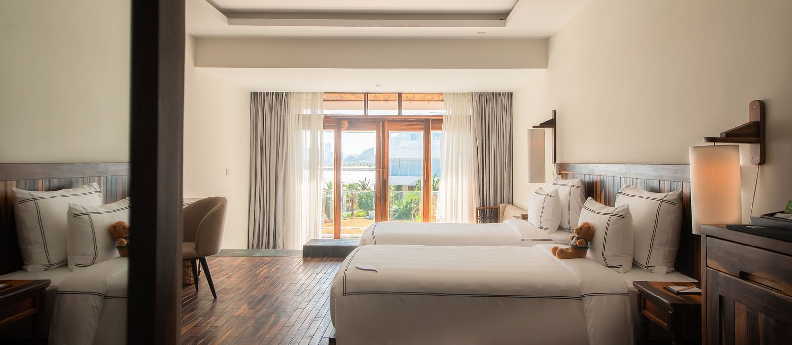 A bedroom at our resort seen from the entrance with a plush bed and comfortable furniture to rest - Alibu Resort Nha Trang