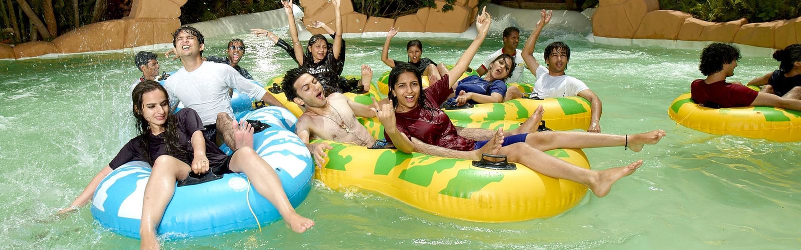 Water Kingdom - a group of people enjoying themselves on inflated tubes at Adventure Amazonia during daytime