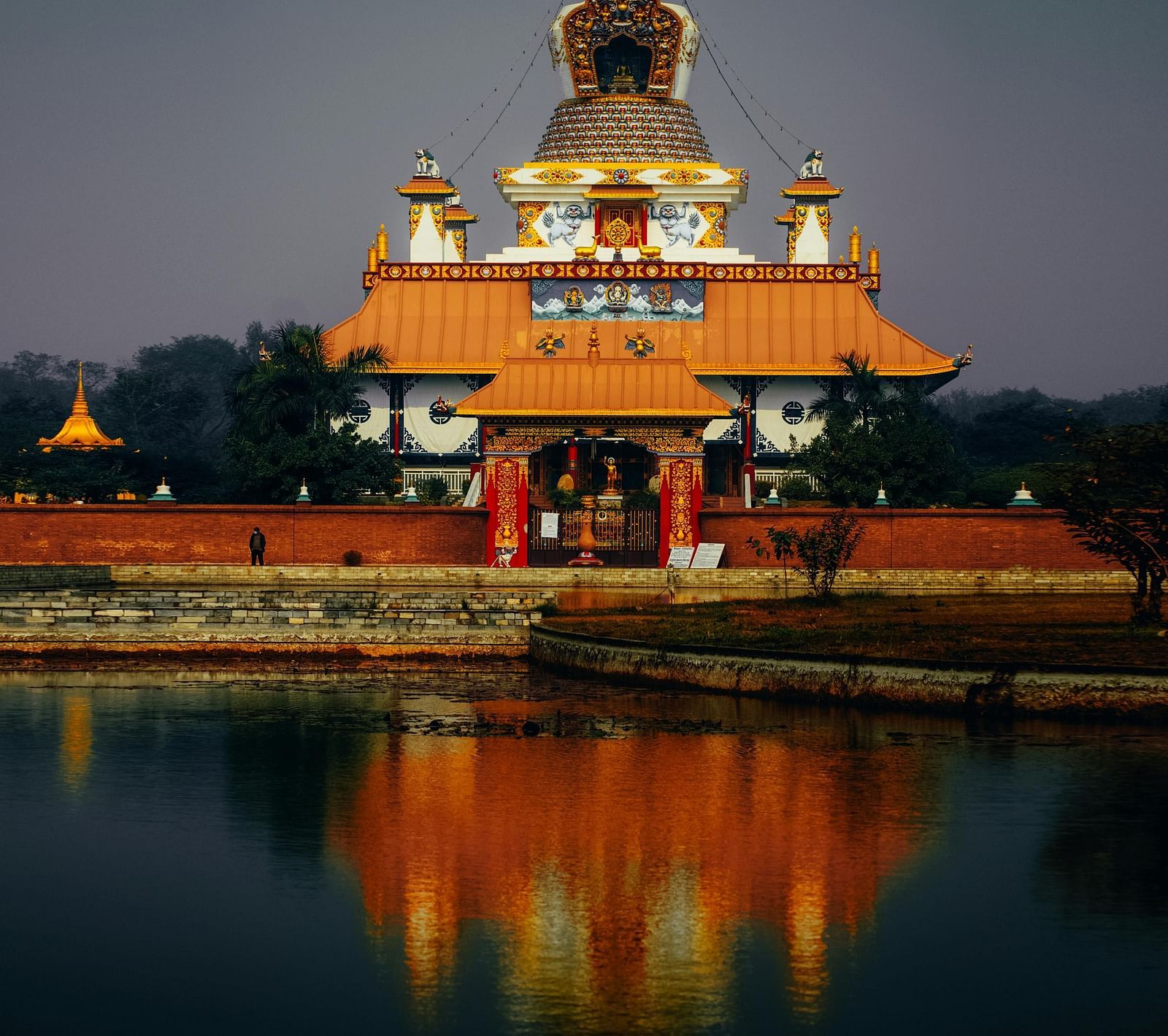 The Japanis Temple at Lumbini, reflected in the water, likely a pond or lake, in the foreground.