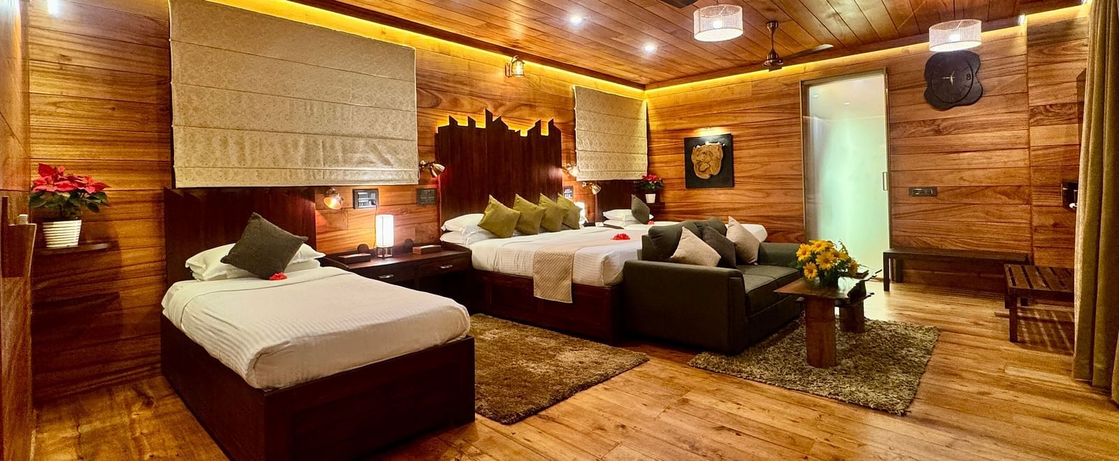 Wood-panelled interior of a room with a seating area and soft warm lighting - BluSalzz Collection - Tranquil Resort, Wayanad