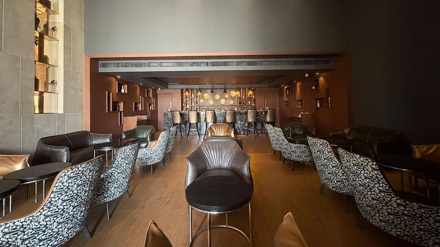 A long shot of a bar with a central fireplace and seating on both sides, emphasizing the bar's layout and focal point.