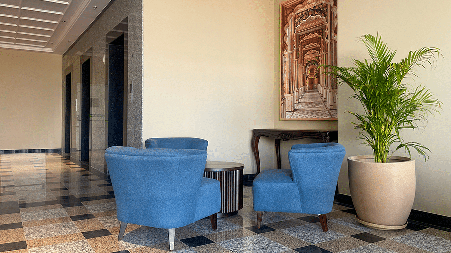 A hotel lobby area with blue armchairs, a small table, a framed artwork, and a potted plant - Urban Suites by BluSalzz, Jaipur