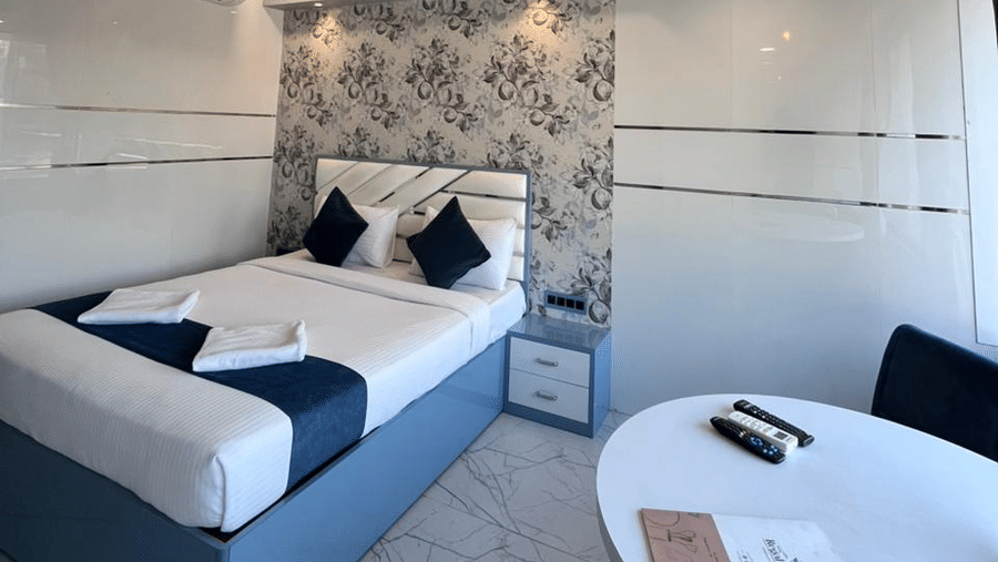 Contemporary hotel room with cosy bedding, sleek furniture, and soft lighting for a comfortable stay.