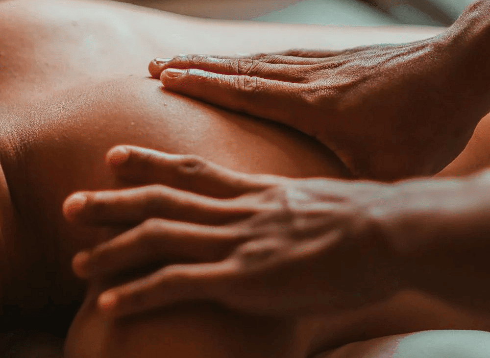 A massage therapist massaging the back of  a person in the spa.