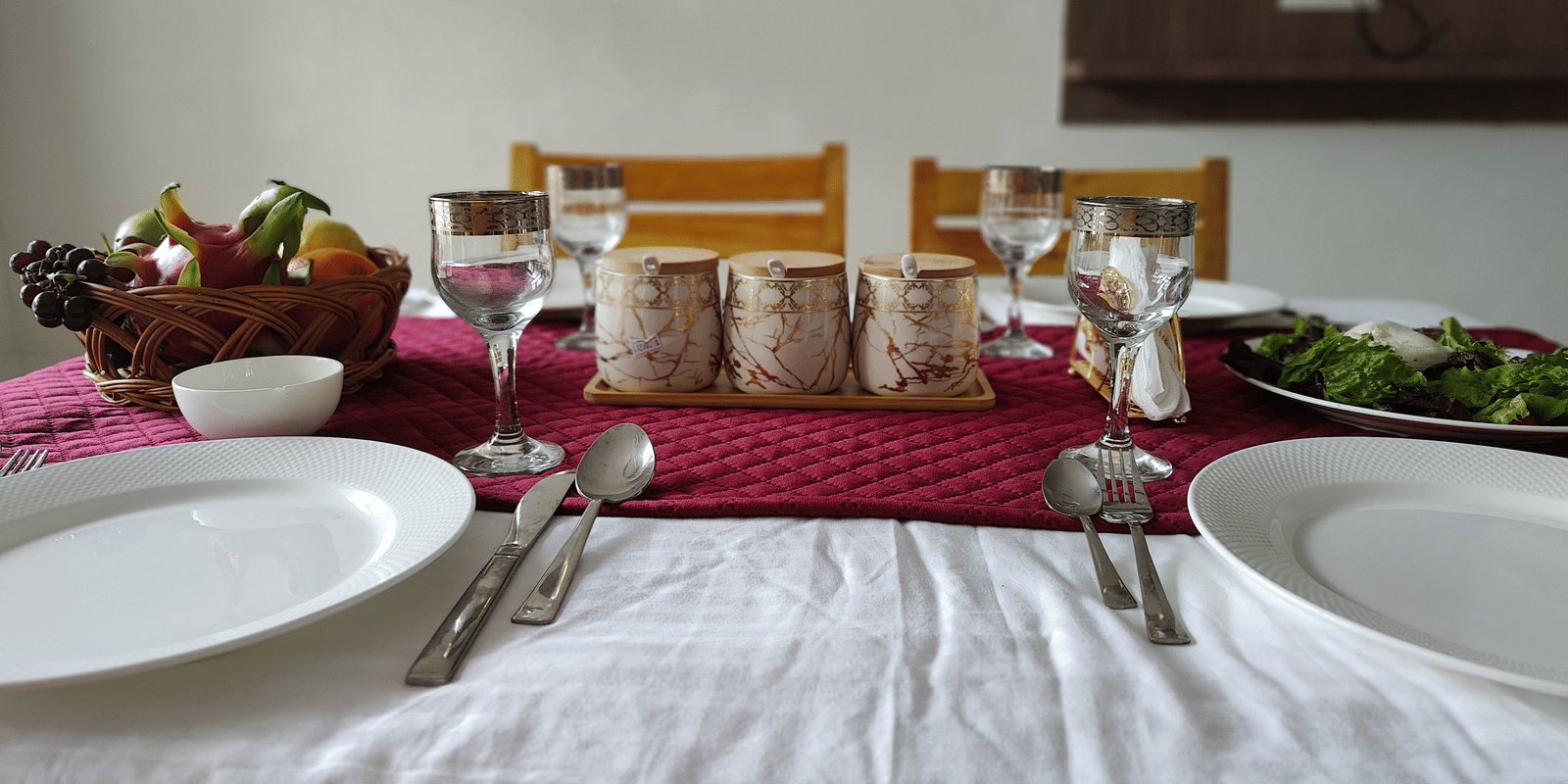 A well-laid table featuring fresh fruit, ceramic mugs, and polished cutlery ready for a meal at Indus Serenity Retreat.
