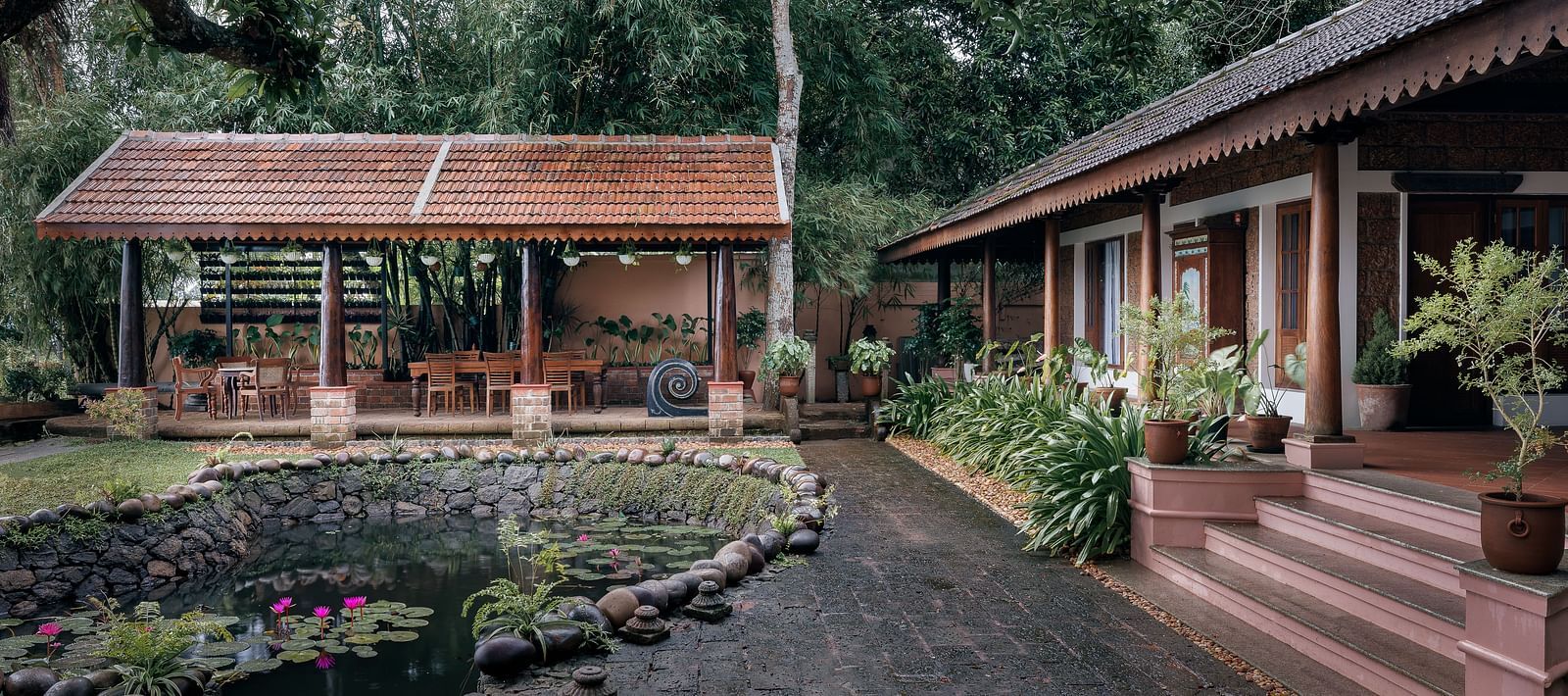 A facade of BluSalzz Villas - Muhamma Resort, Alleppey featuring the pond and the villa on the right and the restaurant in the background