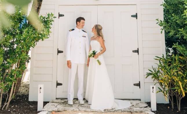 Couple standing in front of a chapel and palm trees, Abaco Inn.