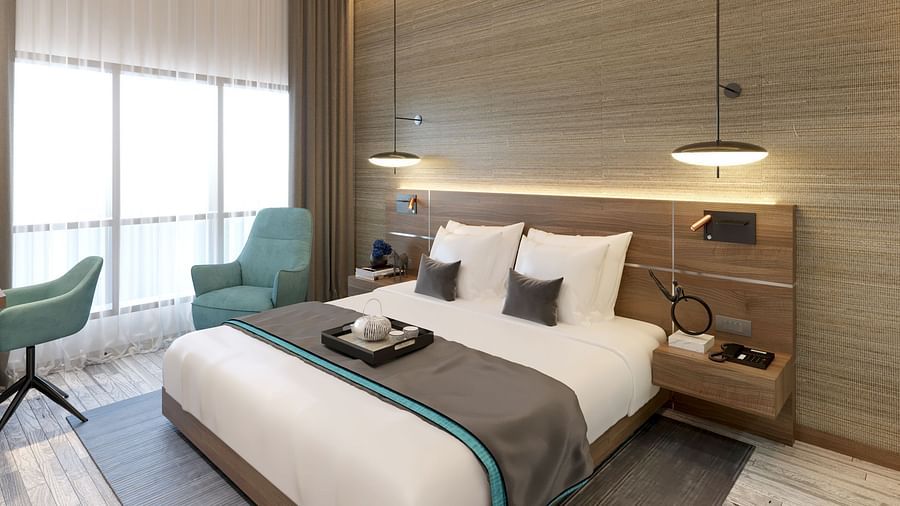 One Bedroom Suite in Kinshasa at Kertel Suites featuring a plush double bed with an arm chair besides it