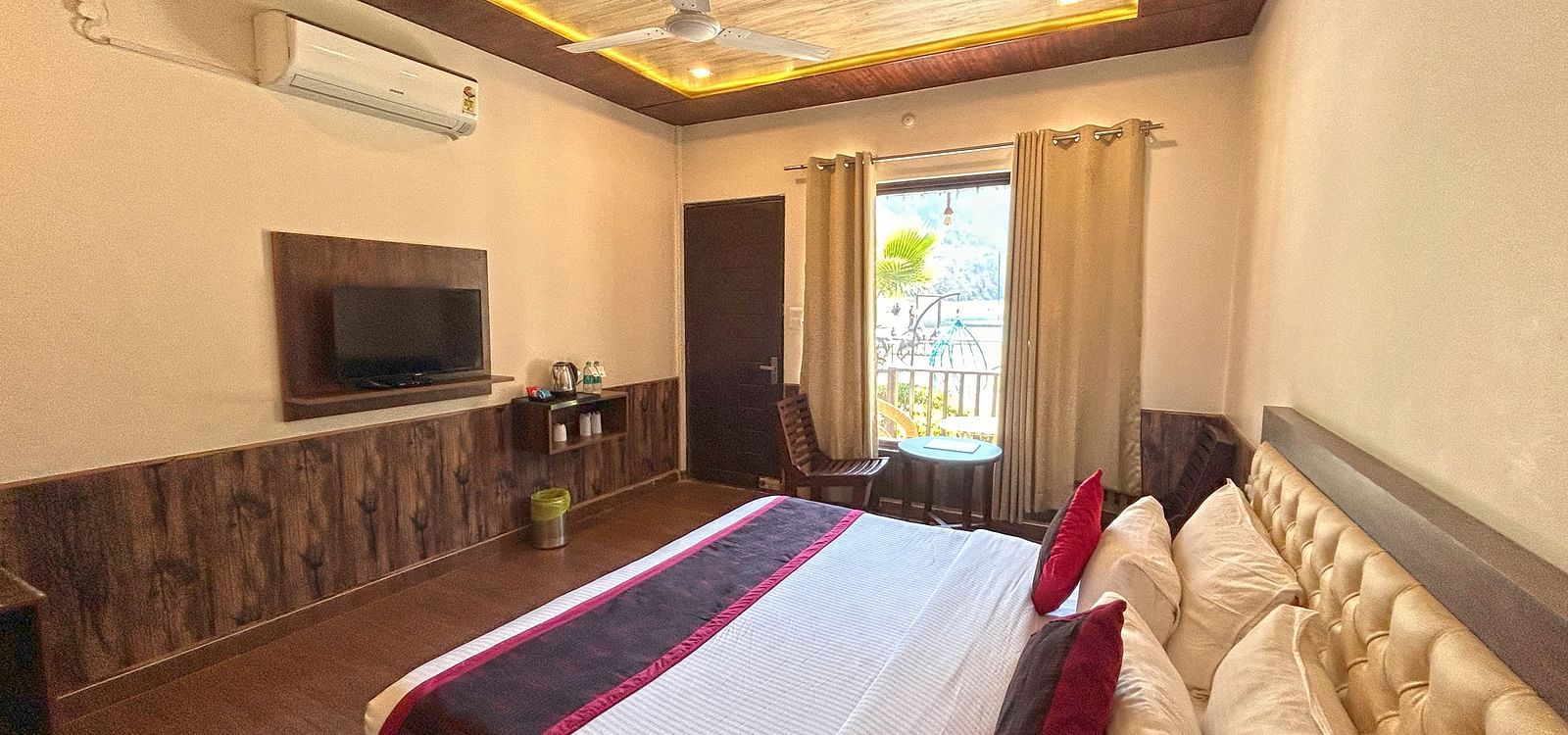 A Luxury Cottage with a large bed in front of the TV at DLS MJ River Resort, Rishikesh.