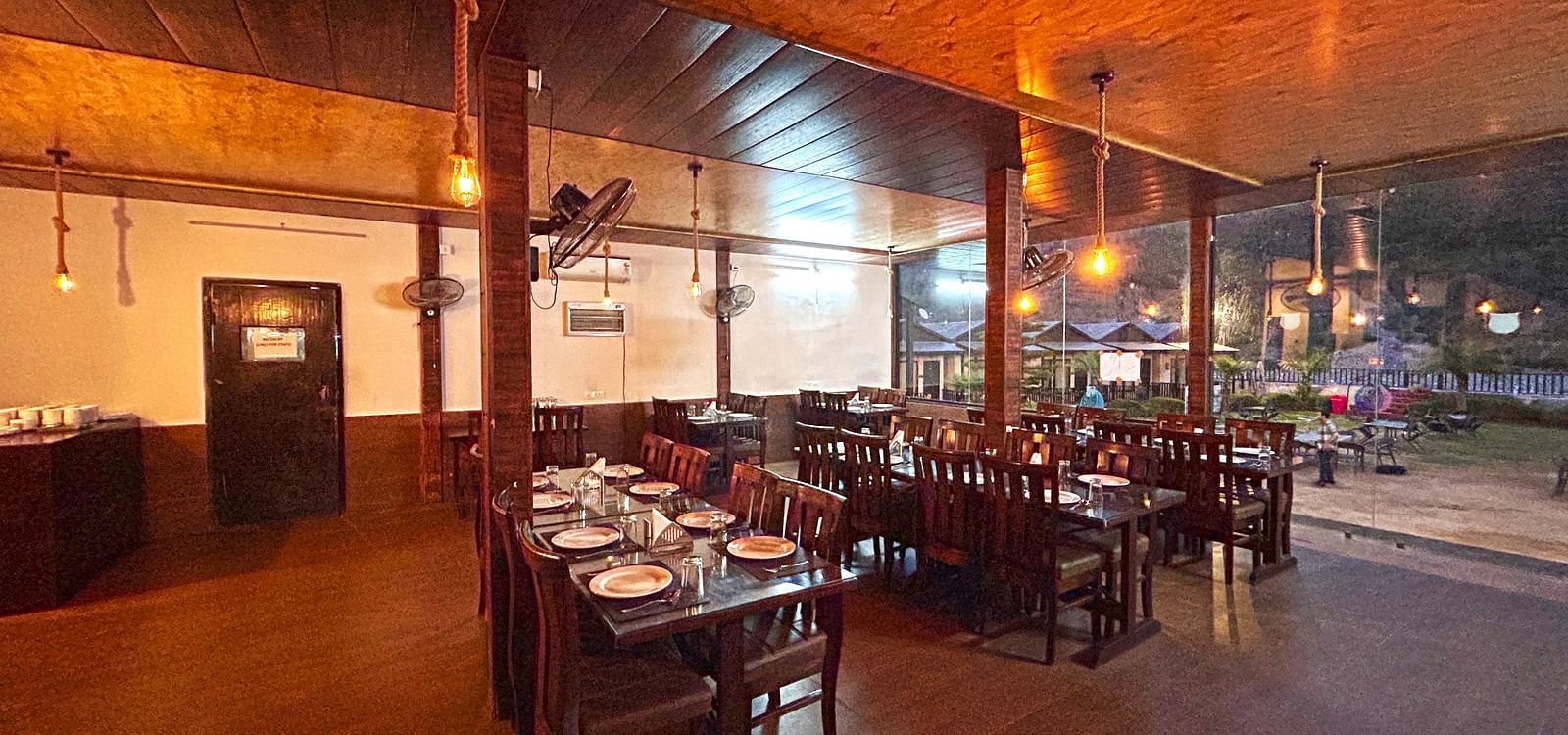Dining area of the in-house restaurant at DLS MJ River Resort, Rishikesh.