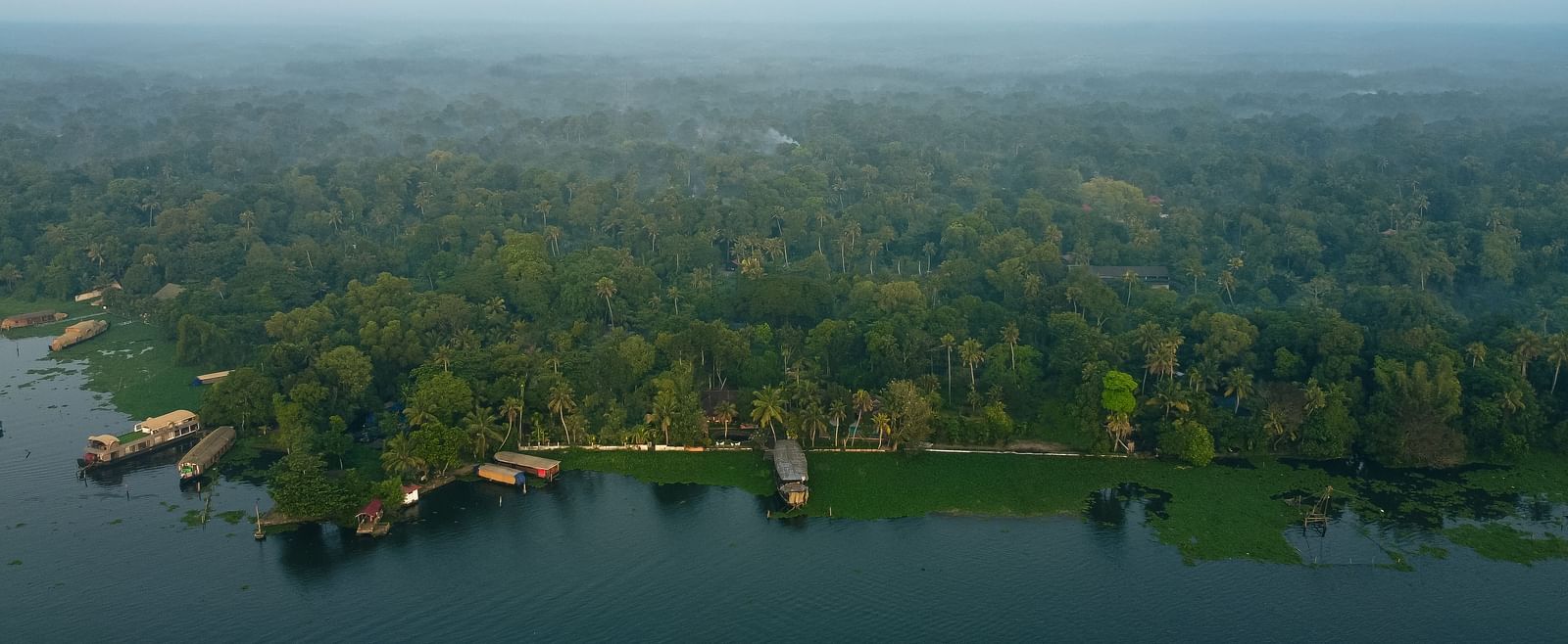An aerial shot of the resort surrounded by lush greenery and the Vembanad Lake in front - BluSalzz Villas - Muhamma Resort, Alleppey