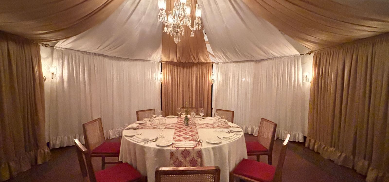 Jalsa hall at Saraca Hotel, Lucknow with a chandelier and a dining arrangement in the centre