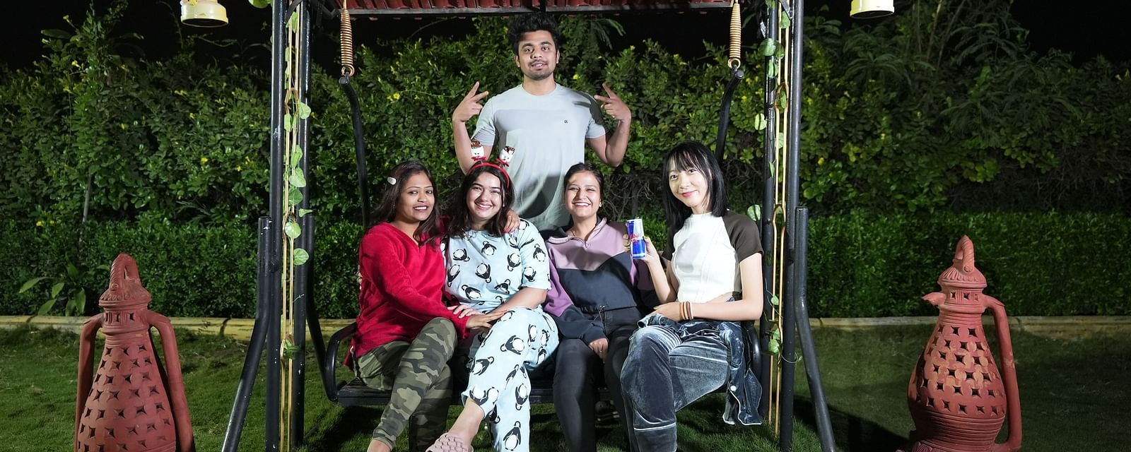 Group of friends posing for a photo on a swing in a garden at night | Diamond Parks, Pune